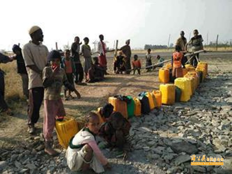 ▲難民營的大人、小孩提著水桶，等待裝下乾淨的水